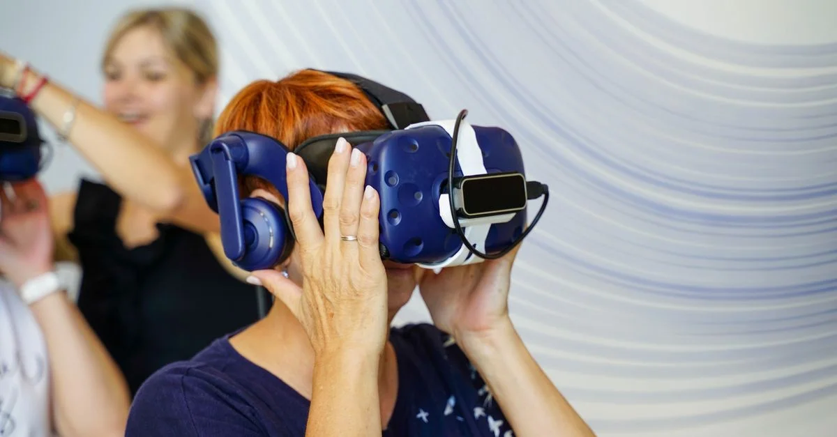Groupe d'adultes profitant d'une expérience de réalité virtuelle avec des casques VR à l'intérieur.