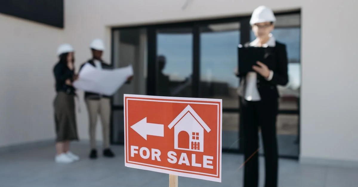 Trois professionnels de l'immobilier inspectent une propriété à vendre en mettant l'accent sur l'aspect commercial.