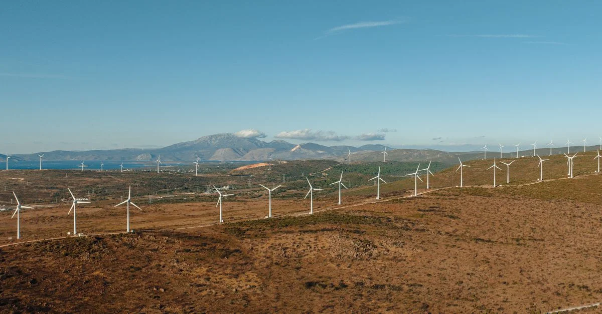 Vue aérienne des éoliennes à Çeşme, en Turquie, sur fond de montagnes.